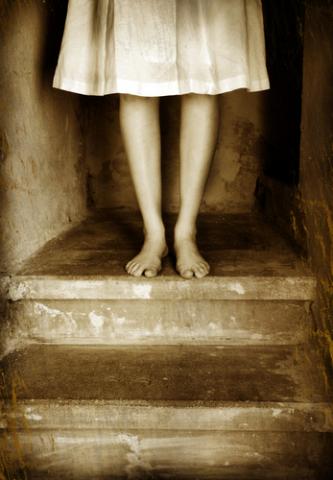 A woman stands alone on the stairs. Photo courtesy Kati Neudert/shutterstock.com
