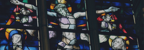 a stained glass window depict Jesus on the cross.