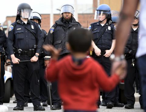 A child waves at law enforcement officers in Baltimore on April 27, 2015. Photo via REUTERS / Sait Serkan Gurbuz Photo via REUTERS / Sait Serkan Gurbuz