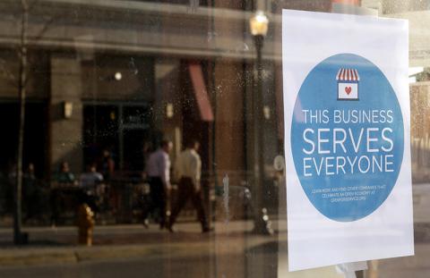 A sign is placed in the window of Bernadette’s Barbershop in Lafayette, Ind. Photo courtesy of REUTERS / Nate Chute / RNS Photo courtesy of REUTERS / Nate Chute / RNS