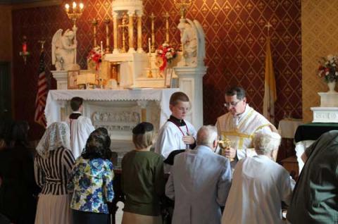 Father Kevin Robinson distributes Communion at St. Michael the Archangel Chapel in N.Y. RNS photo by Gregory A. Shemitz RNS photo by Gregory A. Shemitz