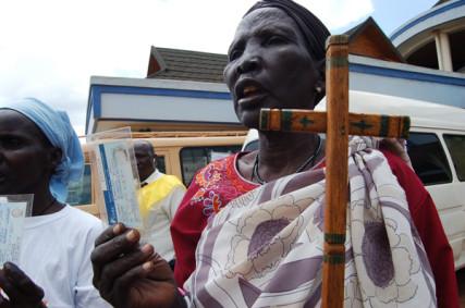 A Sudanese Christian woman carries a cross. RNS photo by Fredrick Nzwili