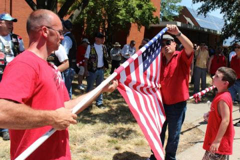 Taylor Hewlett, 9, watches Josh Flowers and Nathan Rascher put away a flag across from the church. RNS photo by Kellie Kotraba RNS photo by Kellie Kotraba