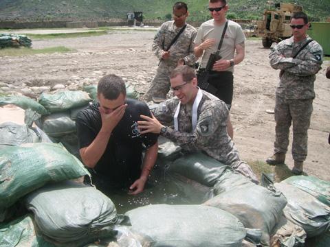 Army Chaplain Capt. Joseph Odell baptizes a fellow soldier on the field in Afghanistan. Photo courtesy RNS.