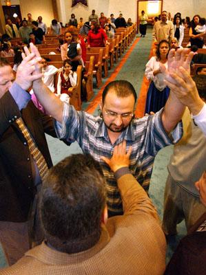Julio Parissi prays for Luis Rosas of Holyoke, Mass. RNS file photo by Mieke Zuiderweg