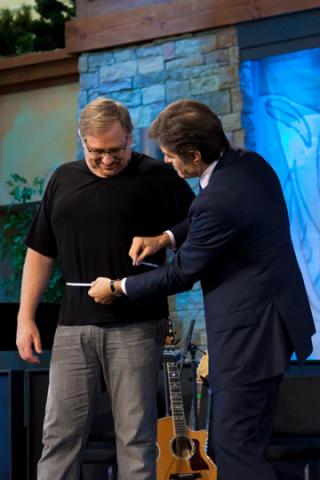 Dr. Oz measures pastor Rick Warren’s waistline at a “Daniel Plan” forum. RNS photo courtesy of Toby Crabtree/Saddleback Church RNS photo courtesy of Toby Crabtree/Saddleback Church