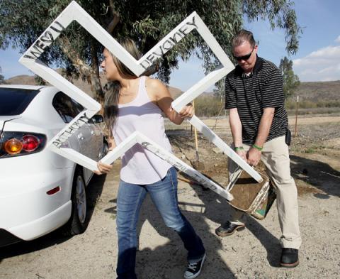 Mercedez Devaney, 24, and her father Chad Devaney remove a roadside cross. Photo: ©Frank Bellino/Press Enterprise/ZUMAPRESS.com