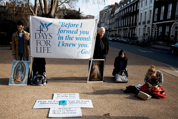 Protesters hold signs outside an abortion clinic in central London