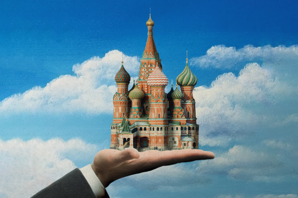 The illustration shows a hand in priests robes holding St. Basils Cathedral in Moscow