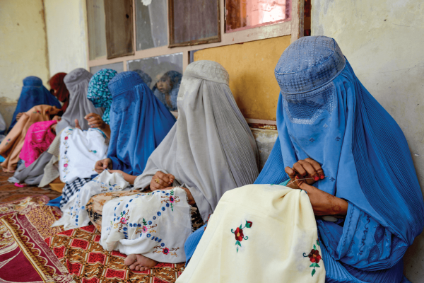 Afghan women embroider handkerchiefs at a workshop. 