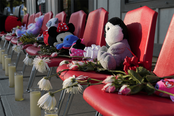 Plush toys on red chairs covered with flowers and candles.