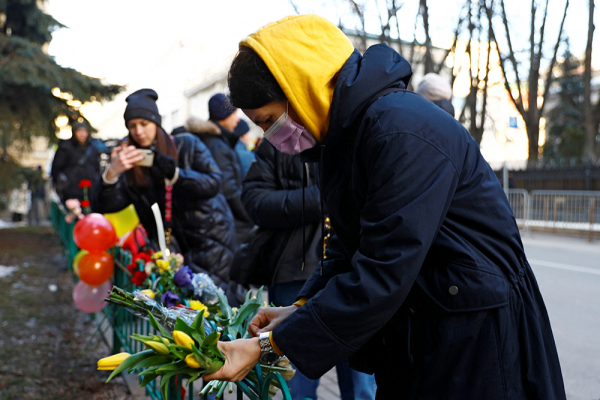 A woman places flowers outside the Ukrainian embassy in Moscow after Russia launched a massive military operation against Ukraine on Feb. 24, 2022.