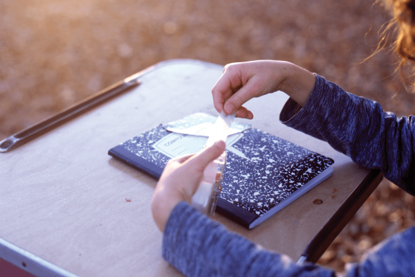 A child sits at a desk with a notebook.