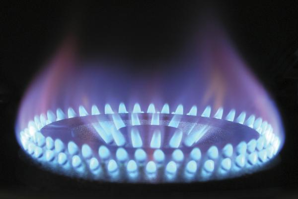 A close-up of the ignited blue flame of a gas cooktop.