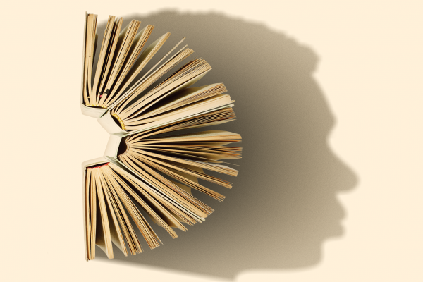A semi-circle of open books casts the shadow of the profile of a human face