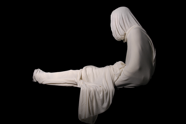 A marble statue of a person with silky fabrics draped over their waist and head.