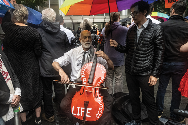 John Mark Rozendaal plays his cello in front of Citibank headquarters in New York City as part of summer-long protests by climate activists, dubbed the "Summer of Heat."