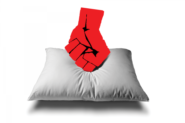A balled fist is punching downward onto a pillow.