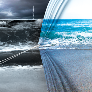 A. man pulling what looks like a curtain, bringing in an image of a calm beach scene over a stormy scene.