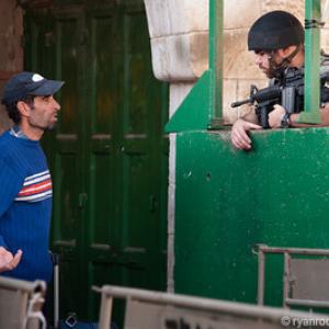 A Palestinian man is questioned at an Israeli military checkpoint. 