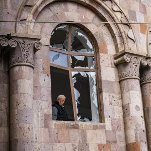 Man stands in destroyed window of a church