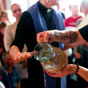 The hands of the author and ordainee, Matthew Nickoloff, in the baptismal font. 