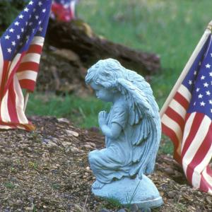 Close-up of a statue and an American flag, Purestock / Getty Images