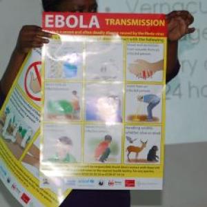The Rev. Pauline Njiru, of Kenya displays a poster showing how Ebola can be tran