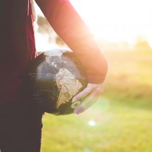 A white person holding a globe, representing white savior complex