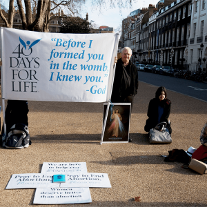 Protesters hold signs outside an abortion clinic in central London