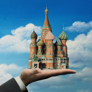 The illustration shows a hand in priests robes holding St. Basils Cathedral in Moscow