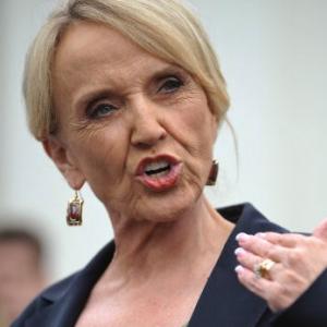 Arizona Gov. Jan Brewer speaks to reporters in 2010. Photo via Getty Images. 