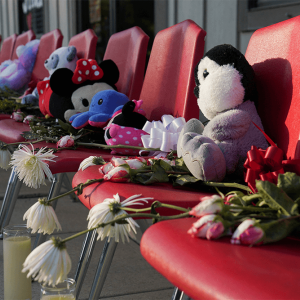 Plush toys on red chairs covered with flowers and candles.