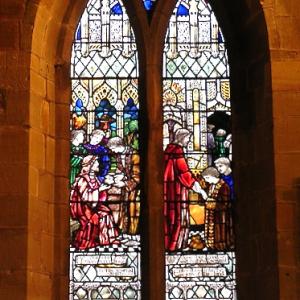 Stained glass church window depicting the Parable of the Talents from Matthew 25