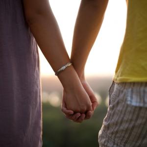 A couple holding hands. Image via Mirko Tabasevic/shutterstock.com