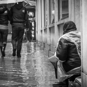 Pedestrians passing by homeless person, uros1210 / Shutterstock.com