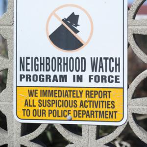 Neighborhood watch sign on a gate. Photo courtesy gabriel12/shutterstock.com