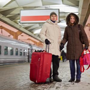 A man and a woman hold hands near a train. Image courtesy Pavel L Photo and Vide