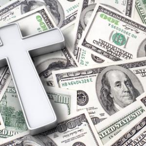 Cross on top of $100 bills, StockThings / Shutterstock.com
