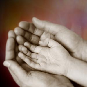 Child hand inside a parent's, mickyso /Shutterstock.com