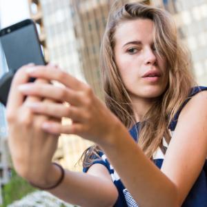  Young woman taking a selfie, Linda Moon / Shutterstock.com
