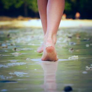 A woman walking on sand. Image courtesy Nikolay Bassov/shutterstock.com.