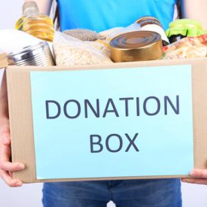 A young man holds a box of donations. Image courtesy Africa Studio/shutterstock.