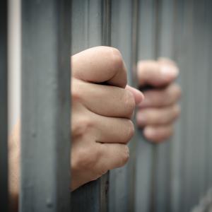 Man behind bars, ANURAK PONGPATIMET / Shutterstock.com