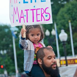 A young girl joins a rally against racism in Washington, DC in August 2014. Imag