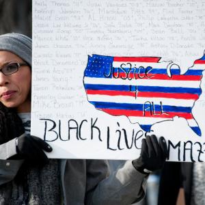 Woman holds a 'Black Lives Matter' sign. Image courtesy Rena Schild/shutterstock