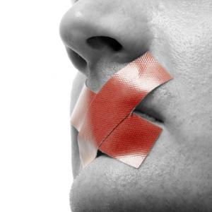 Red tape over mouth photo, Stefan Redel / Shutterstock.com