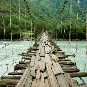 Rickety bridge over rapids. Image via Zastolskiy Victor/shutterstock.com