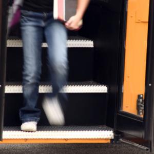 Youth getting off a school bus,  Margie Hurwich / Shutterstock.com