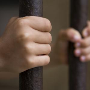 Child behind bars photo, pjcross, Shutterstock.com